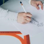 Someone is sketching a design on paper