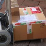 Un chariot transportant deux cartons sur un sol pavé