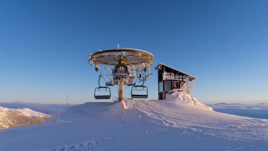 a ski lift sitting on top of a snow covered slope