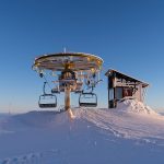 a ski lift sitting on top of a snow covered slope