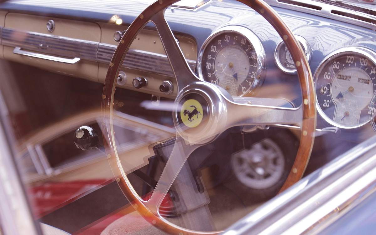 Intérieur d'une voiture ancienne avec volant en bois et compteurs