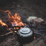 Bivouac de nuit avec feu de camp, équipement de camping et matériel de montagne