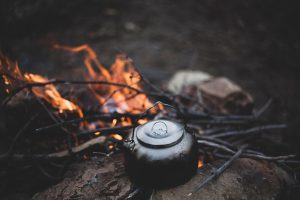 Bivouac de nuit avec feu de camp, équipement de camping et matériel de montagne