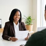 Une femme souriante montre un document à un homme lors d'un entretien