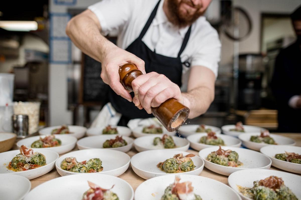 Chef assaisonne des petits plats en cuisine