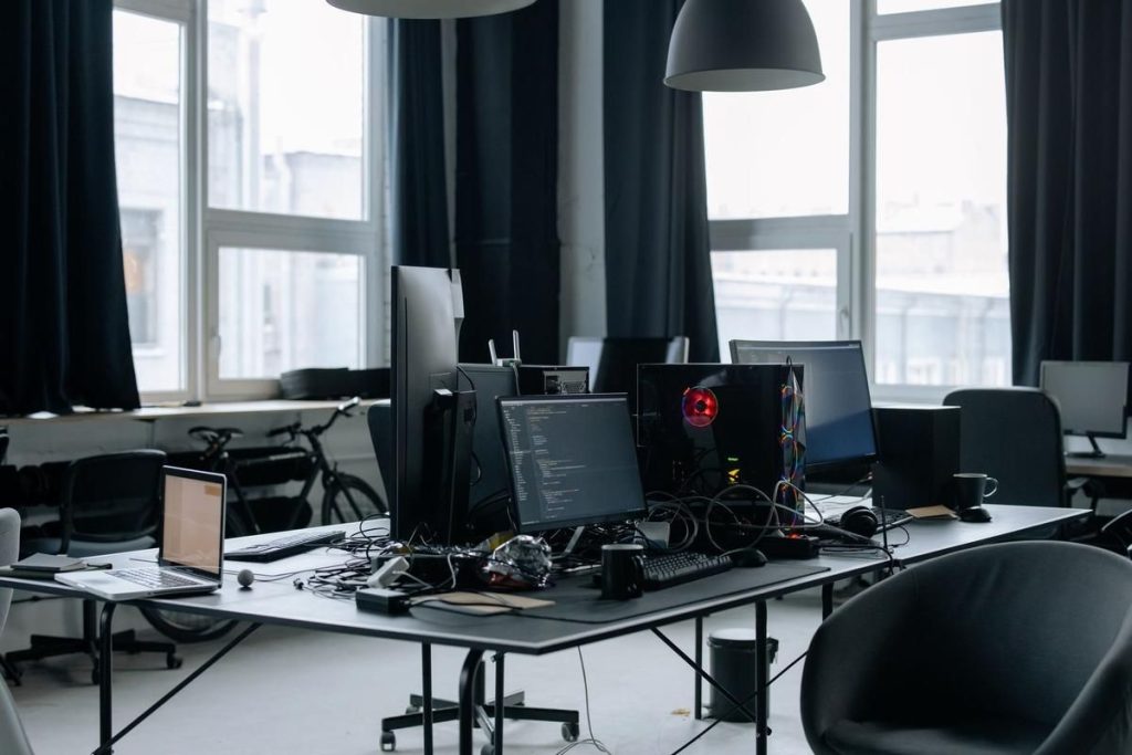 Un bureau moderne avec plusieurs écrans, chaises et lumière naturelle